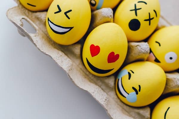 Painted eggs showing a range of emotions in the style of emojis