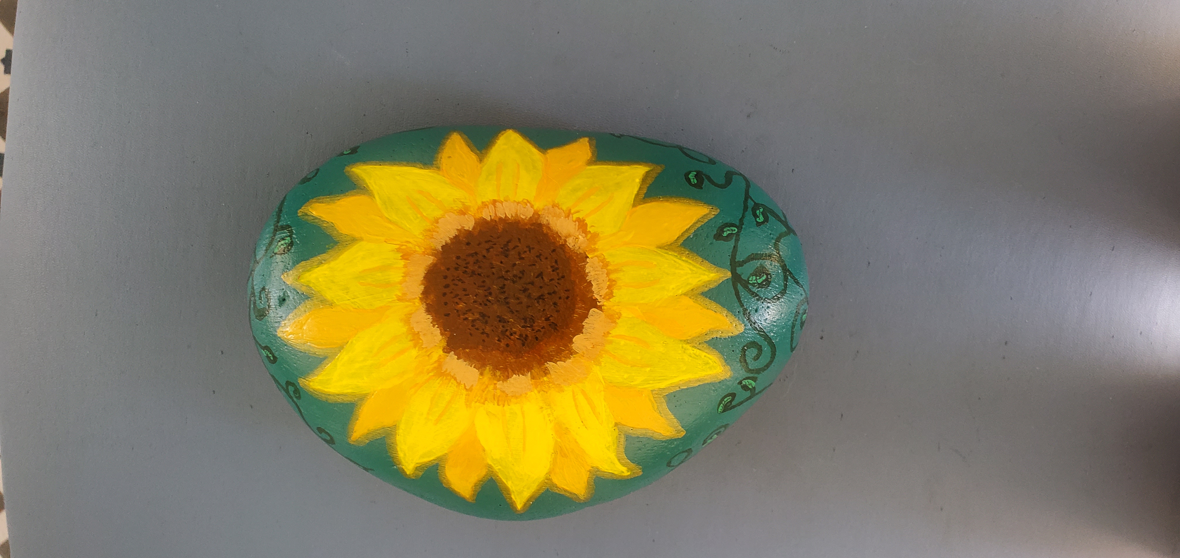 A sunflower painted on a stone