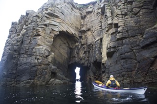 Kayaker next to natural arch, Boddam
