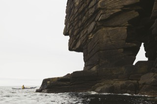 Kayaker next to natural arch, Boddam