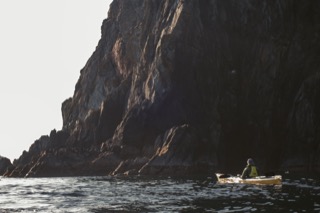 Kayaker below cliffs, Hillswick Ness