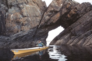 Kayaker and natural arch, Gletness