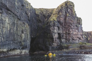Kayaker below Brindister cliffs