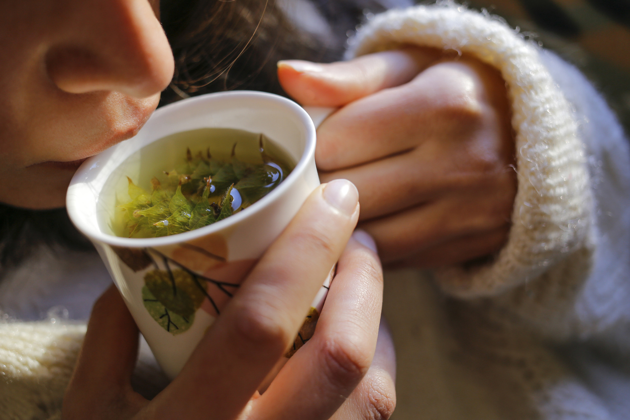 woman sipping from a cup of spearmint tea