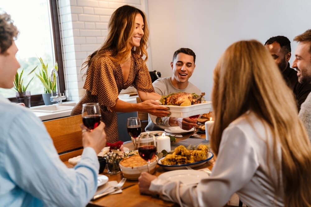 woman bringing a roasted turkey to the dinner table