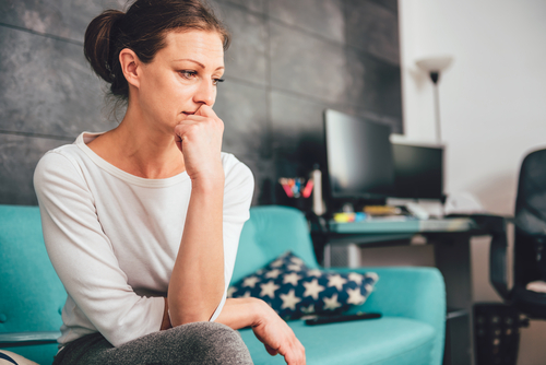 distressed woman on the sofa suffering a chemical pregnancy