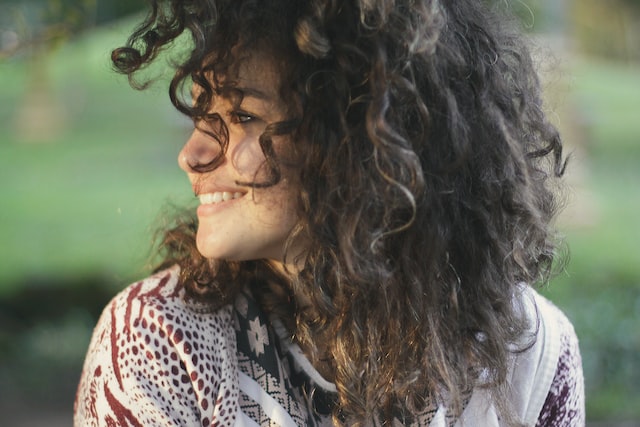 smiling woman againsts a natural green background