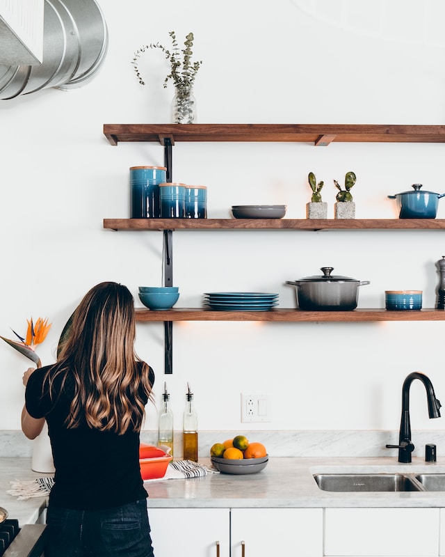 woman arranging a bird of paradise flower in her kitchen