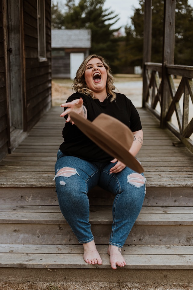 woman laughing and tossing her hat