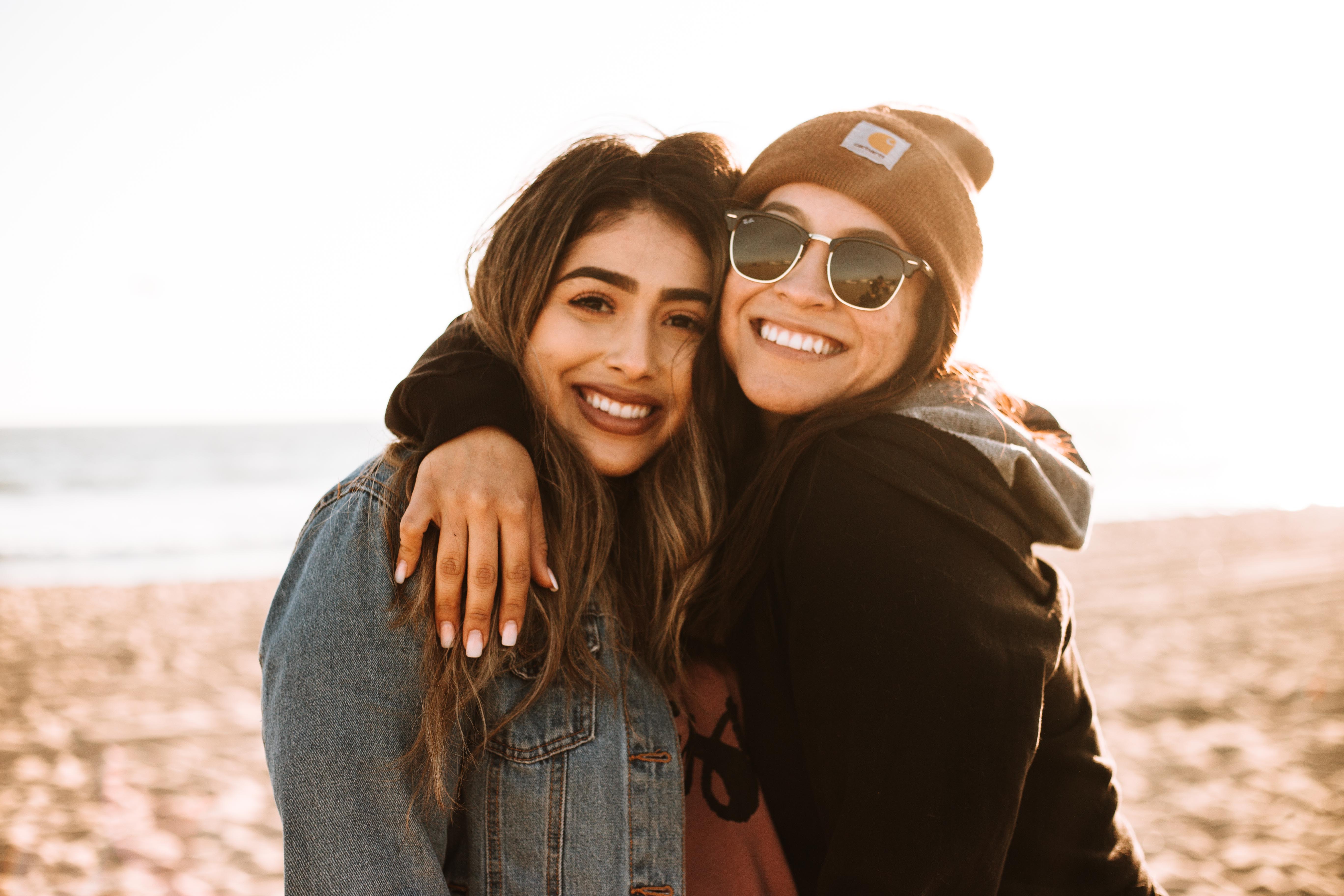 two friends hugging at the beach