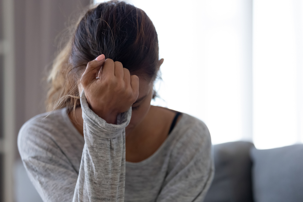 woman hunched over in fear or frustration