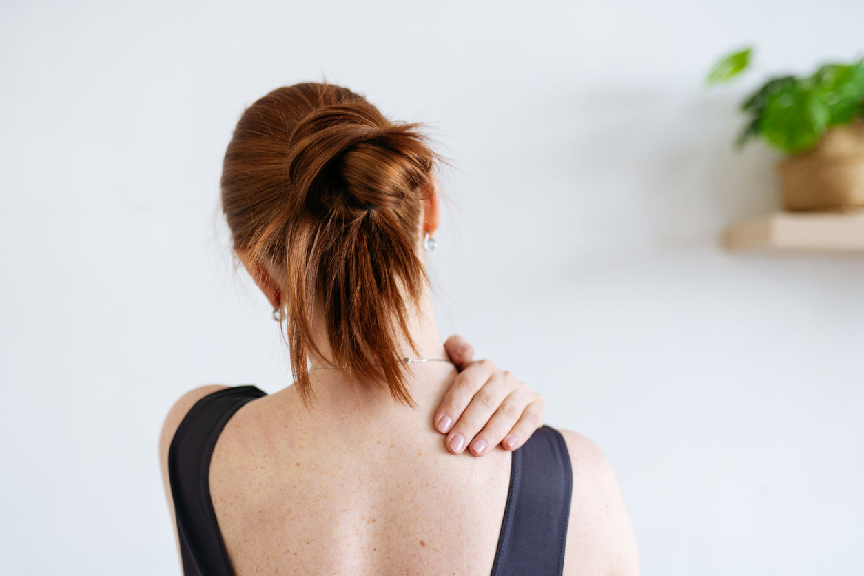 woman rubbing her shoulder