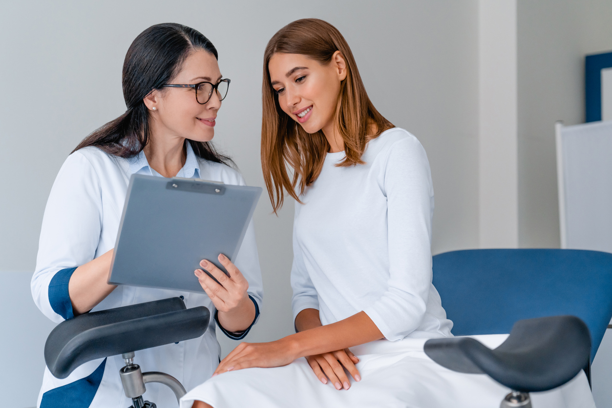 doctor looking at chart with patient during yearly gynecological exam