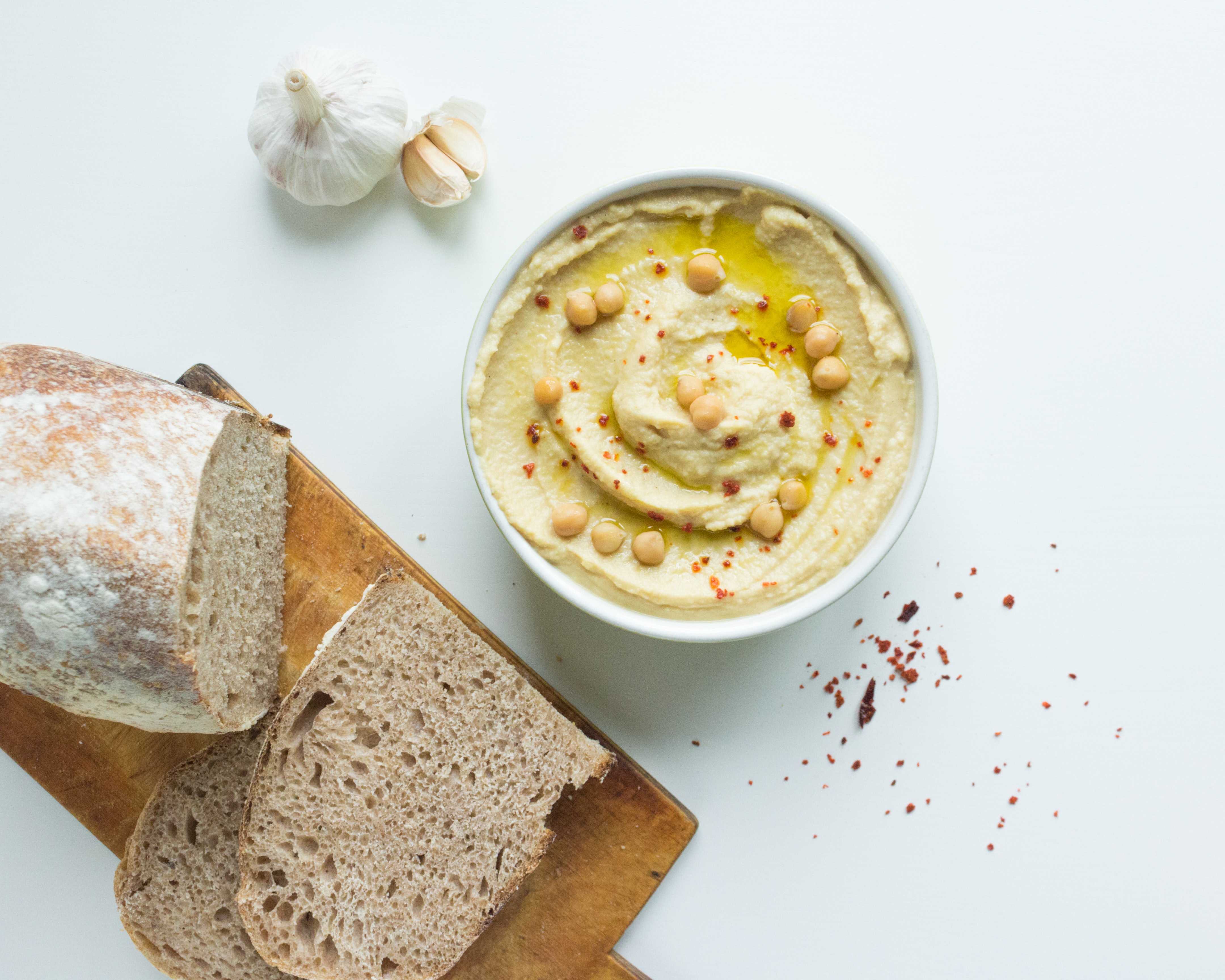 fresh loaf of bread and a bowl of homemade hummus