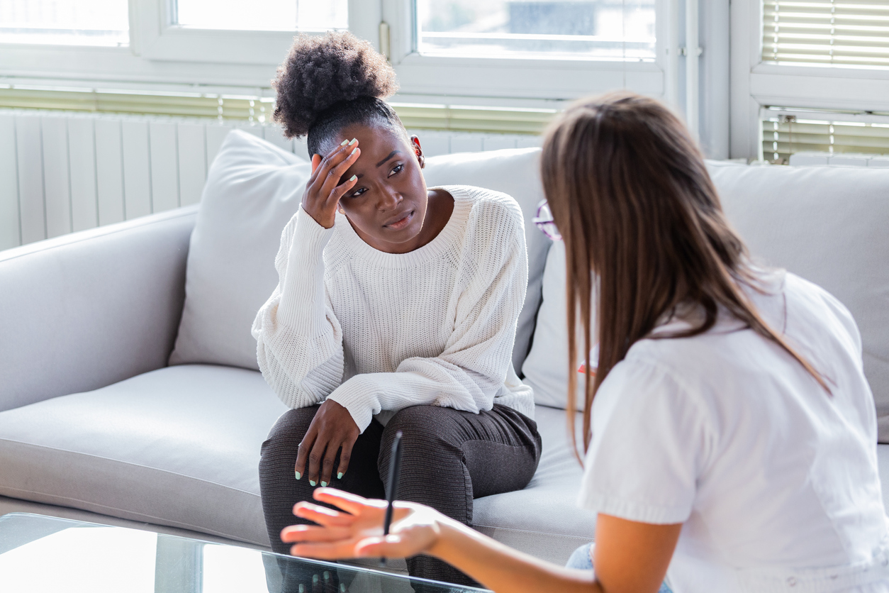 woman with postpartum brain fog talking with a therapist