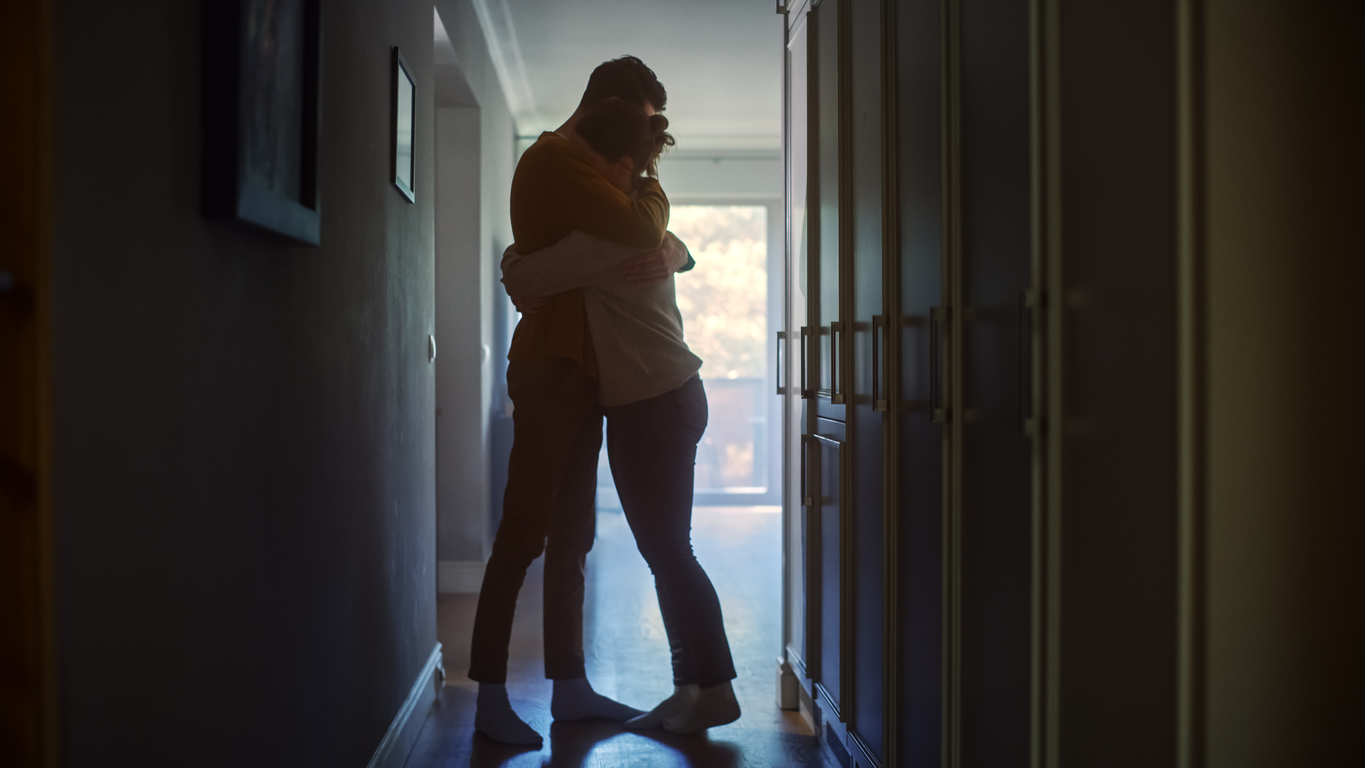 couple comforting each other in a dark hallway