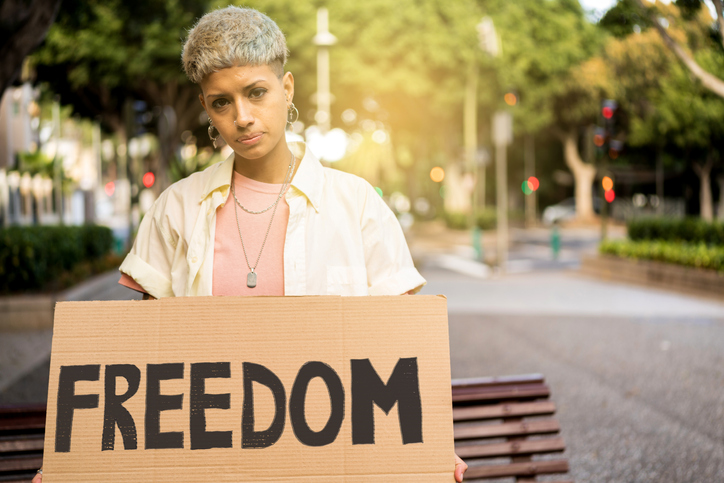 reproductive rights activist holding a sign that reads "freedom"