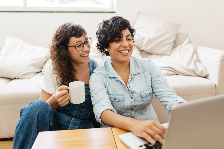 lesbian couple looking at their IUI results on a laptop