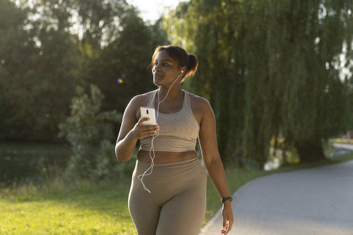 woman exercising in the park while listening to music