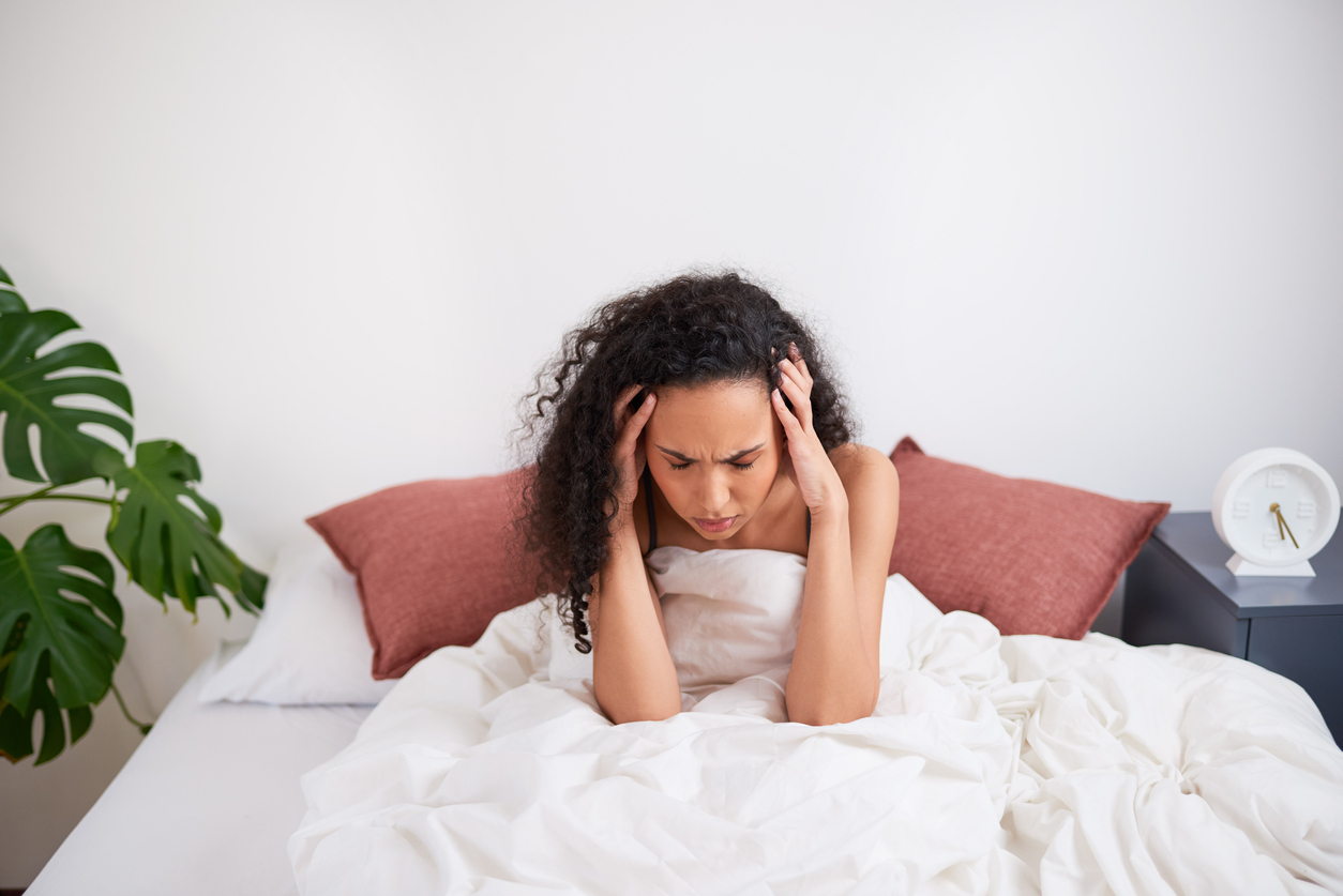 woman in bed with a headache