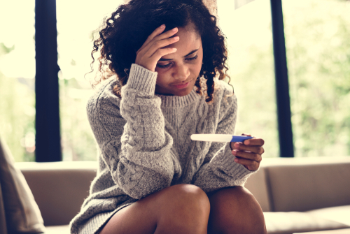 woman reading a pregnancy test