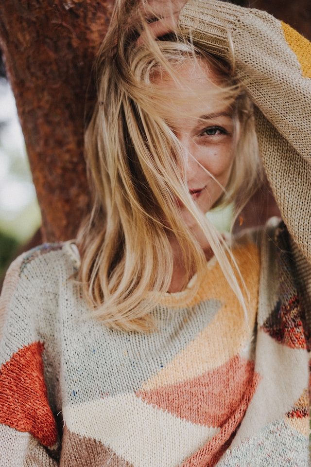 woman smiling against a tree