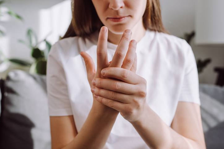 woman in early stages of psoriatic arthritis massaging her hand