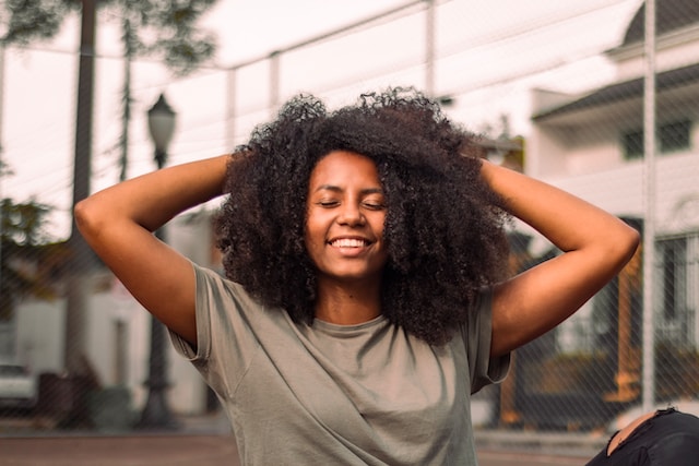 woman with arms balanced on her natural hair