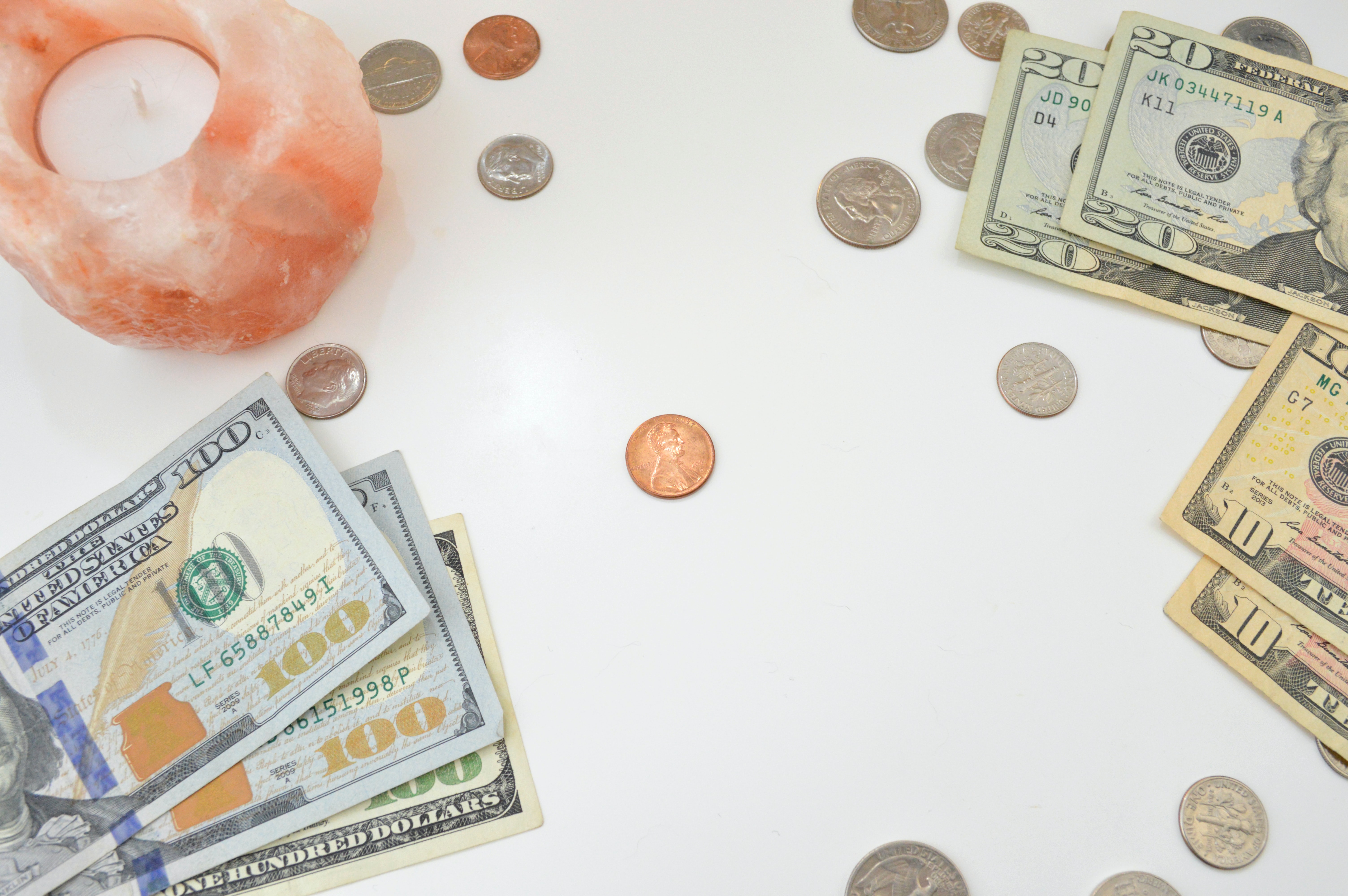 tabletop covered in money, loose change, and a candle