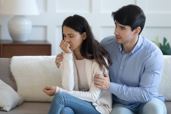 man comforting a woman in distress