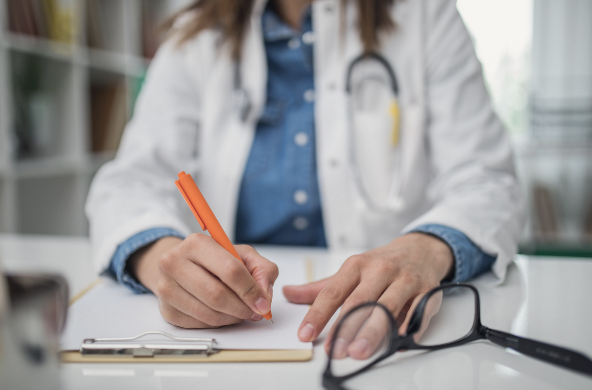 doctor writing notes about a patient