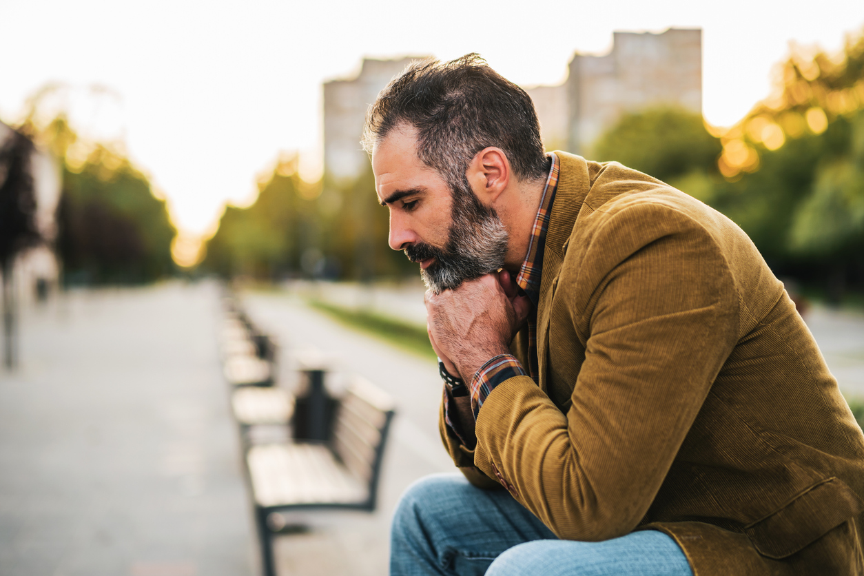 man suffering from seasonal affective disorder on a bench