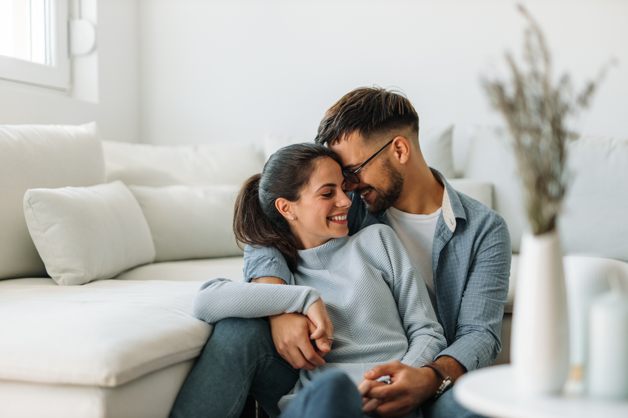 couple cuddling on the floor in front of the sofa