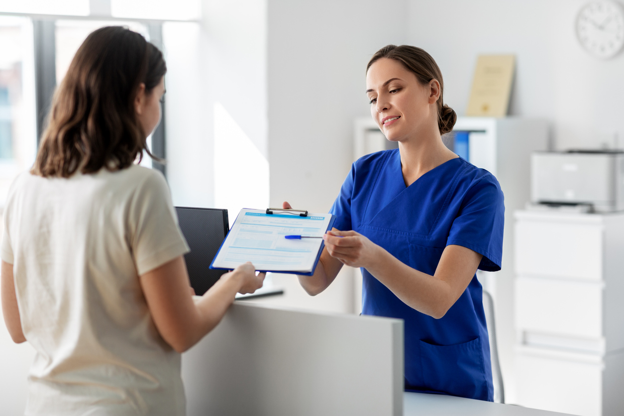 doctor handing a patient an intake form for a leep procedure