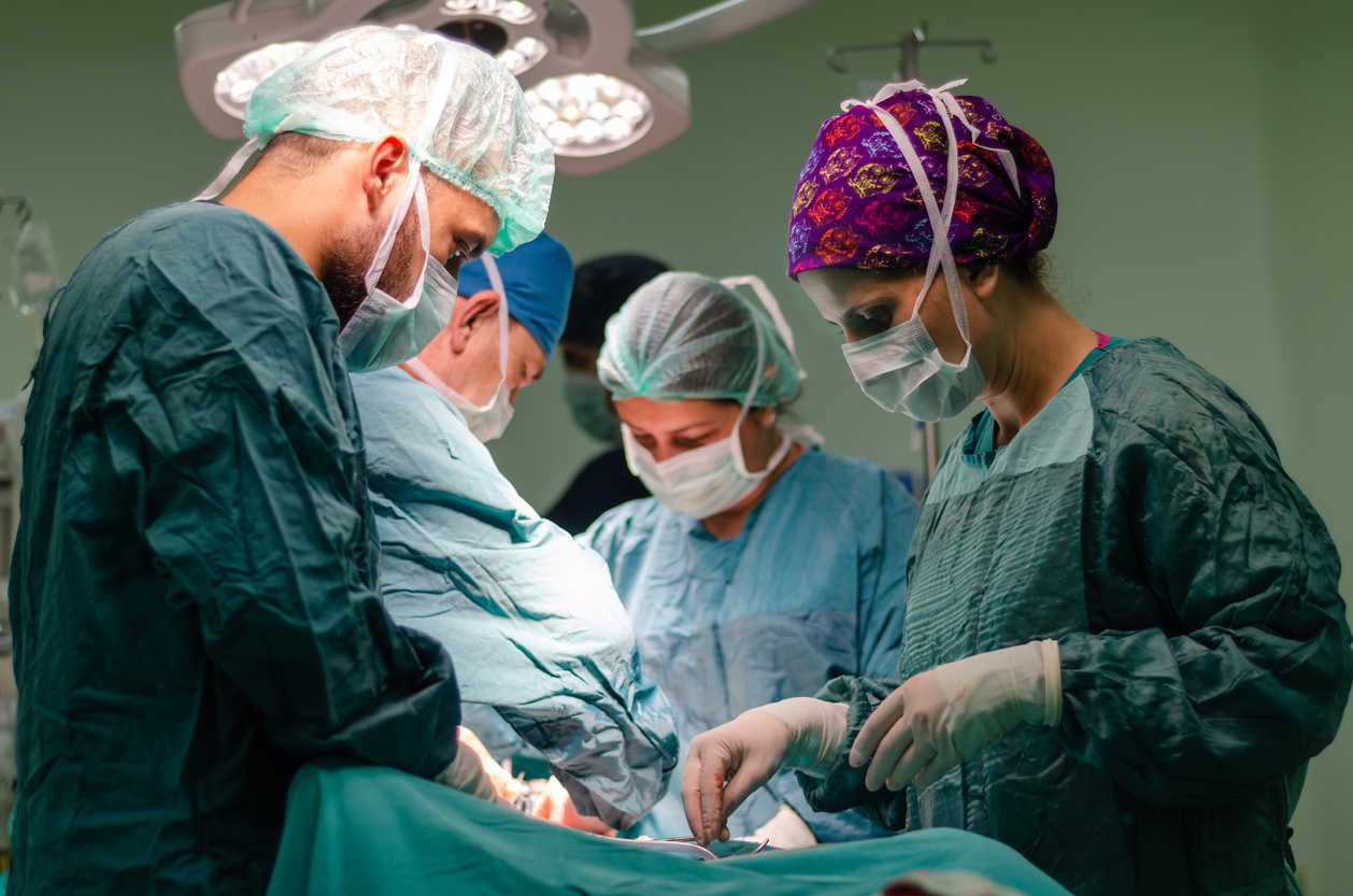 doctors performing abdominal surgery