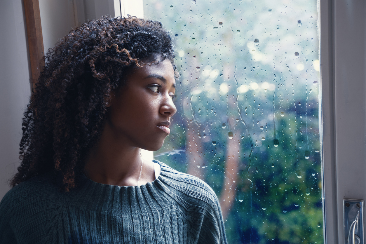 woman looking out the window at the rain