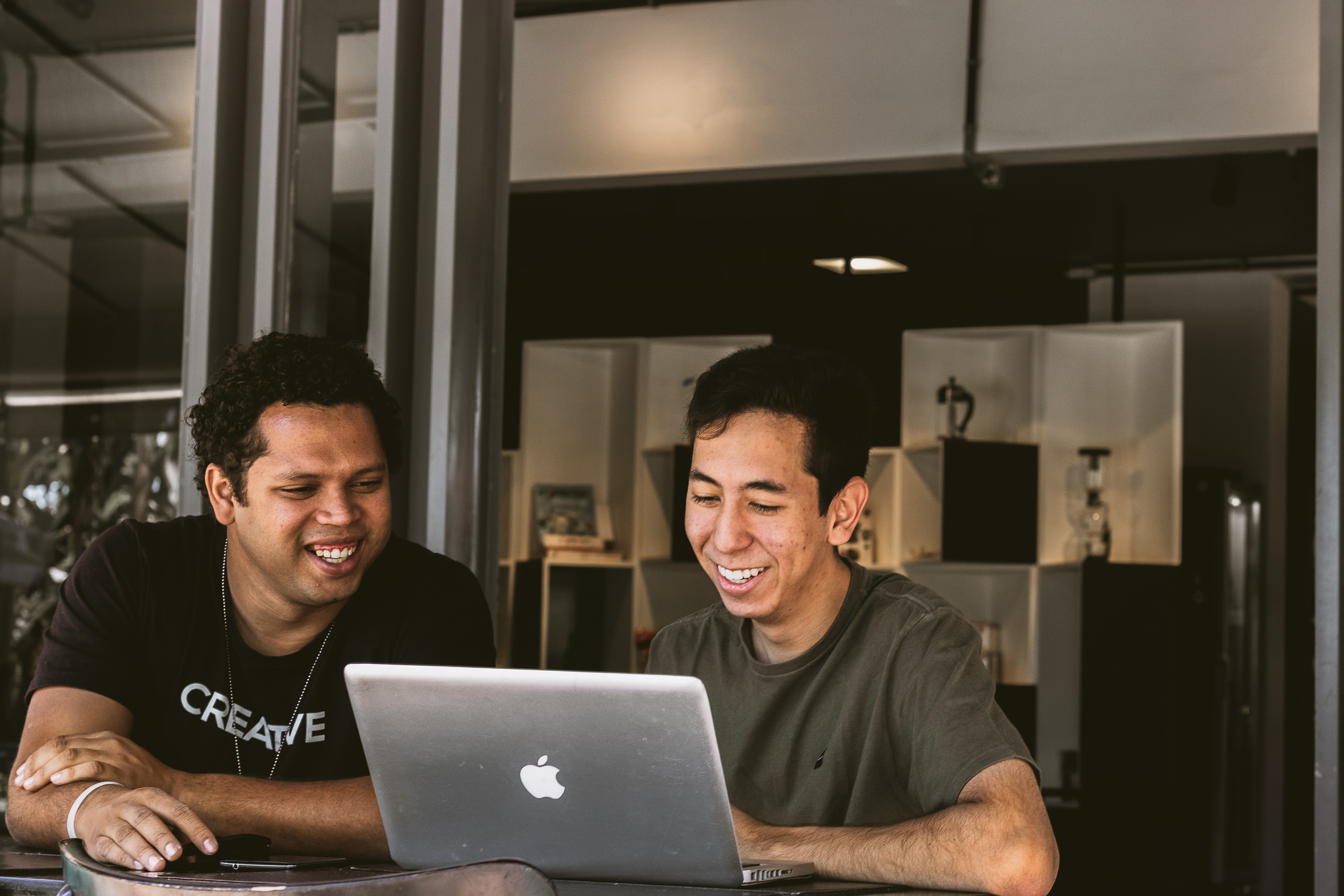 two men looking at a laptop