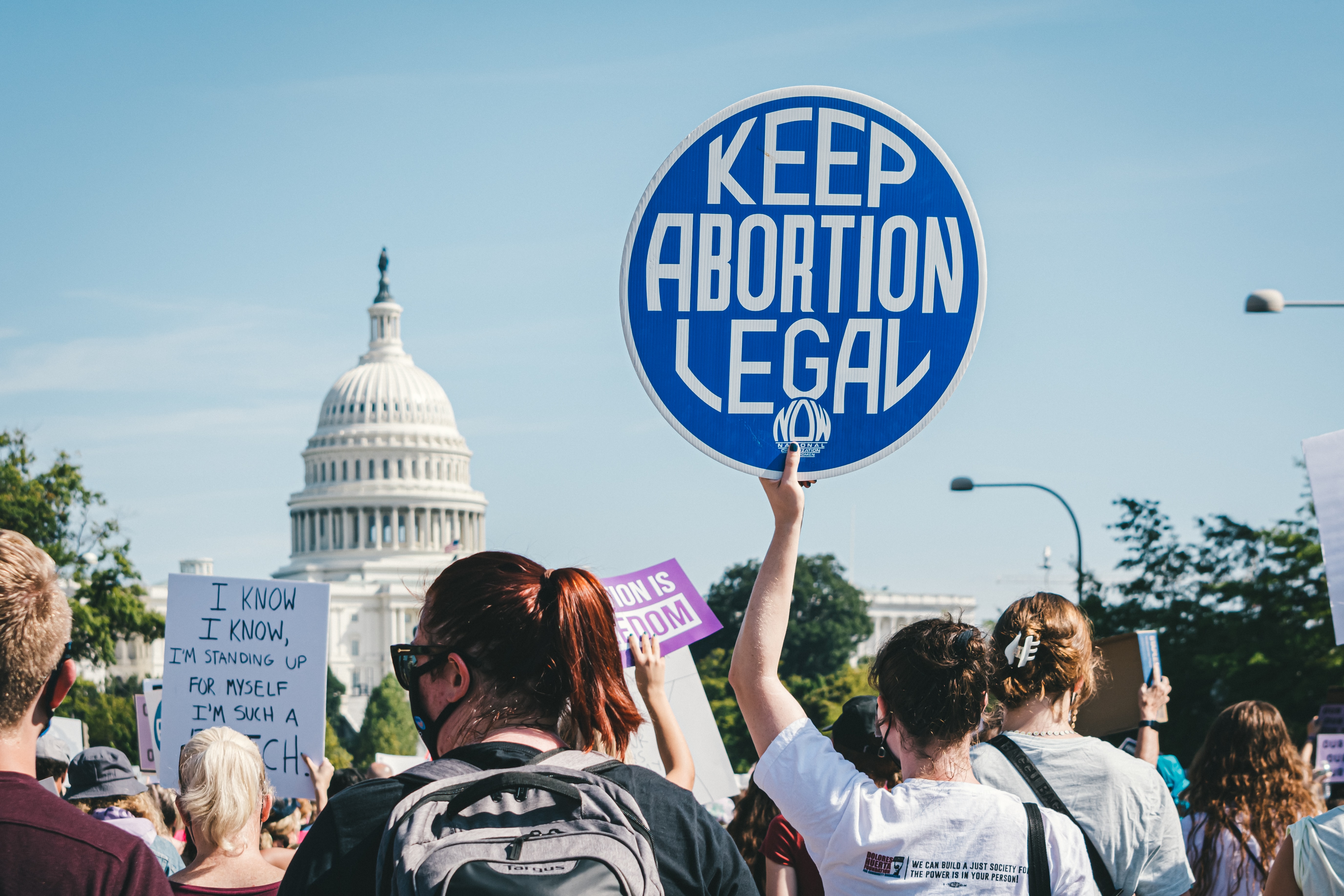 pro-choice protestors in front of the us capitol with sign that reads "keep abortion legal"