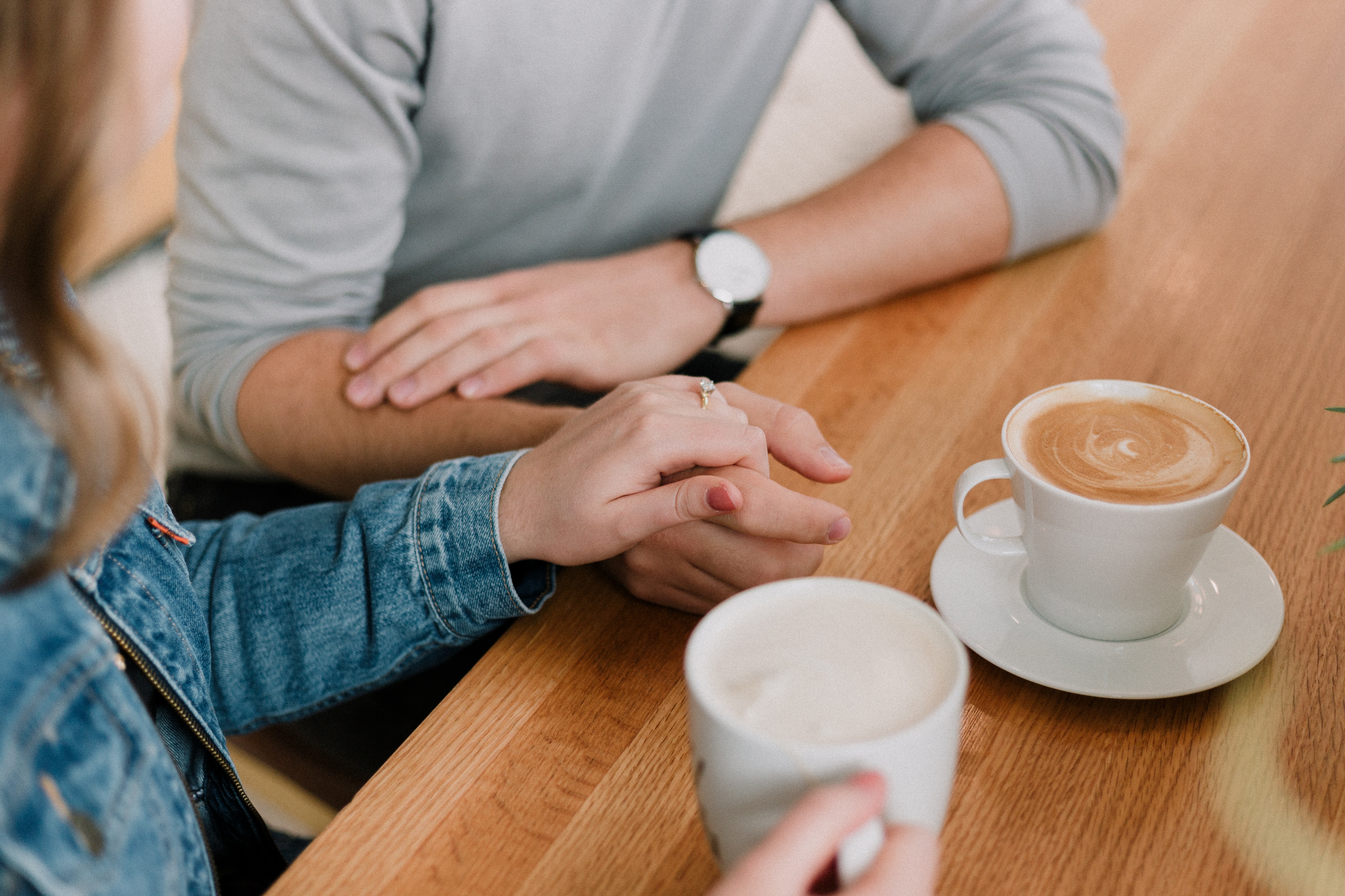 couple holding hands at a coffee shop