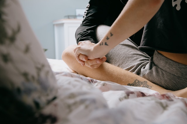 couple cuddling and holding hands in bed