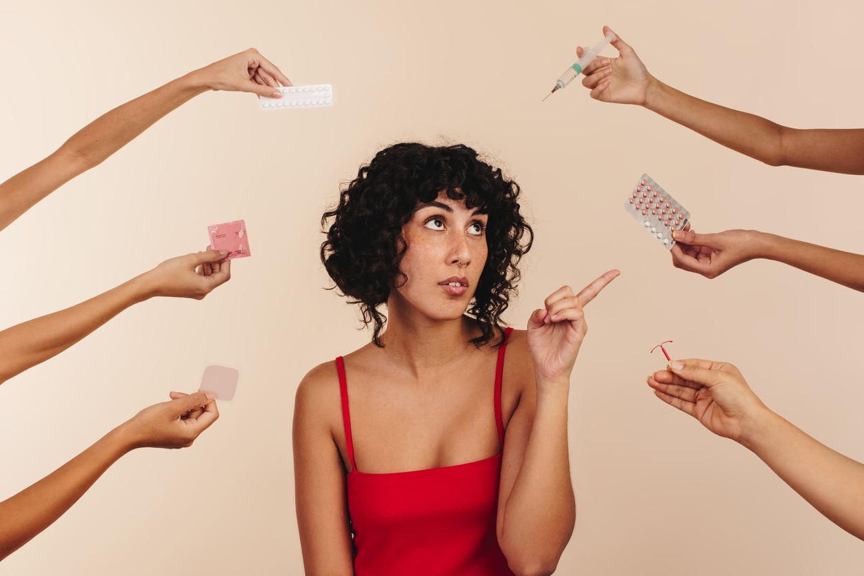 woman saying no to multiple types of birth control in outstretched hands