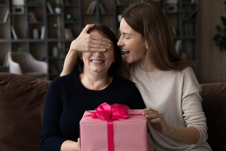 woman surprising her friend with a gift