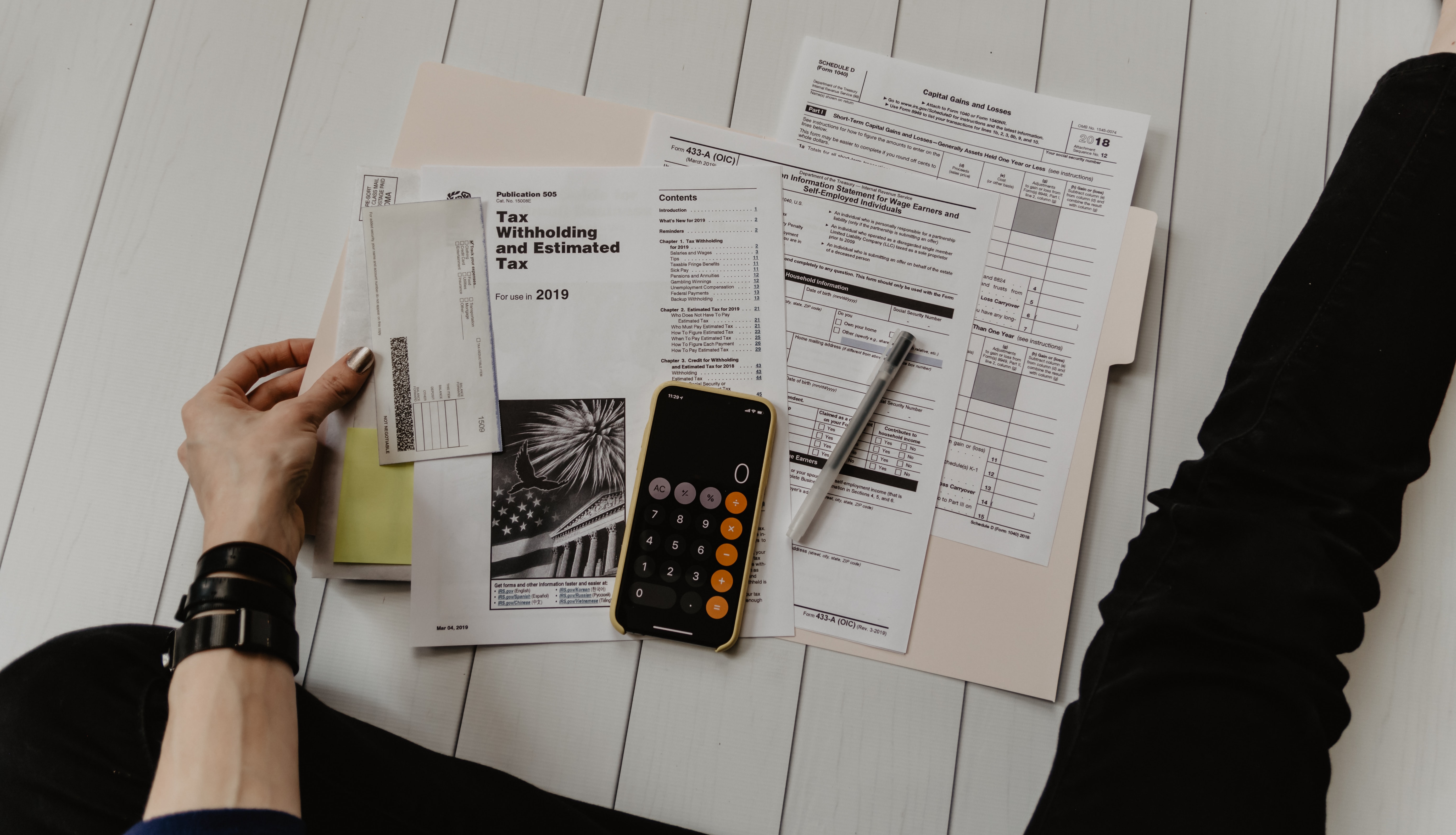 person opening a folder full of tax documents