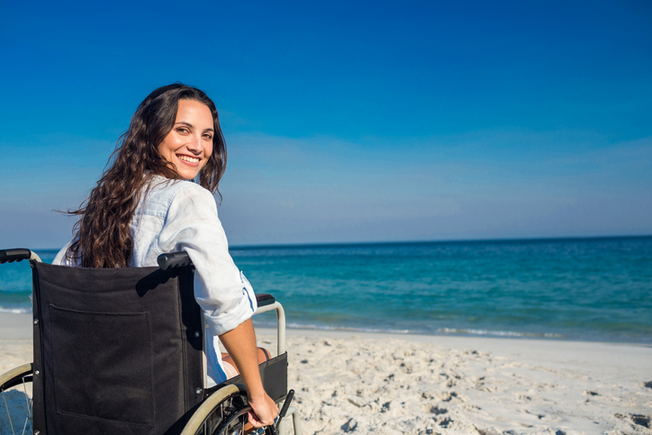 woman in wheelchair sitting on the shore