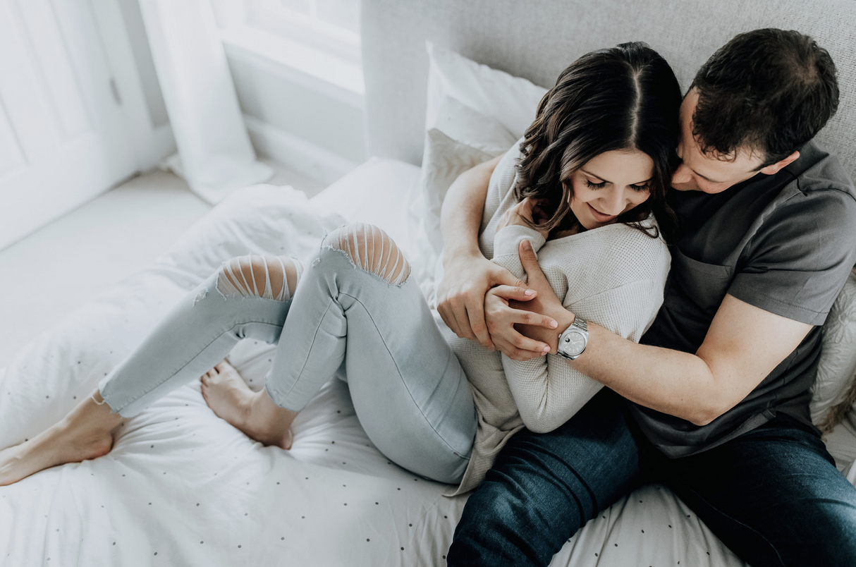 man and woman cuddling in bed