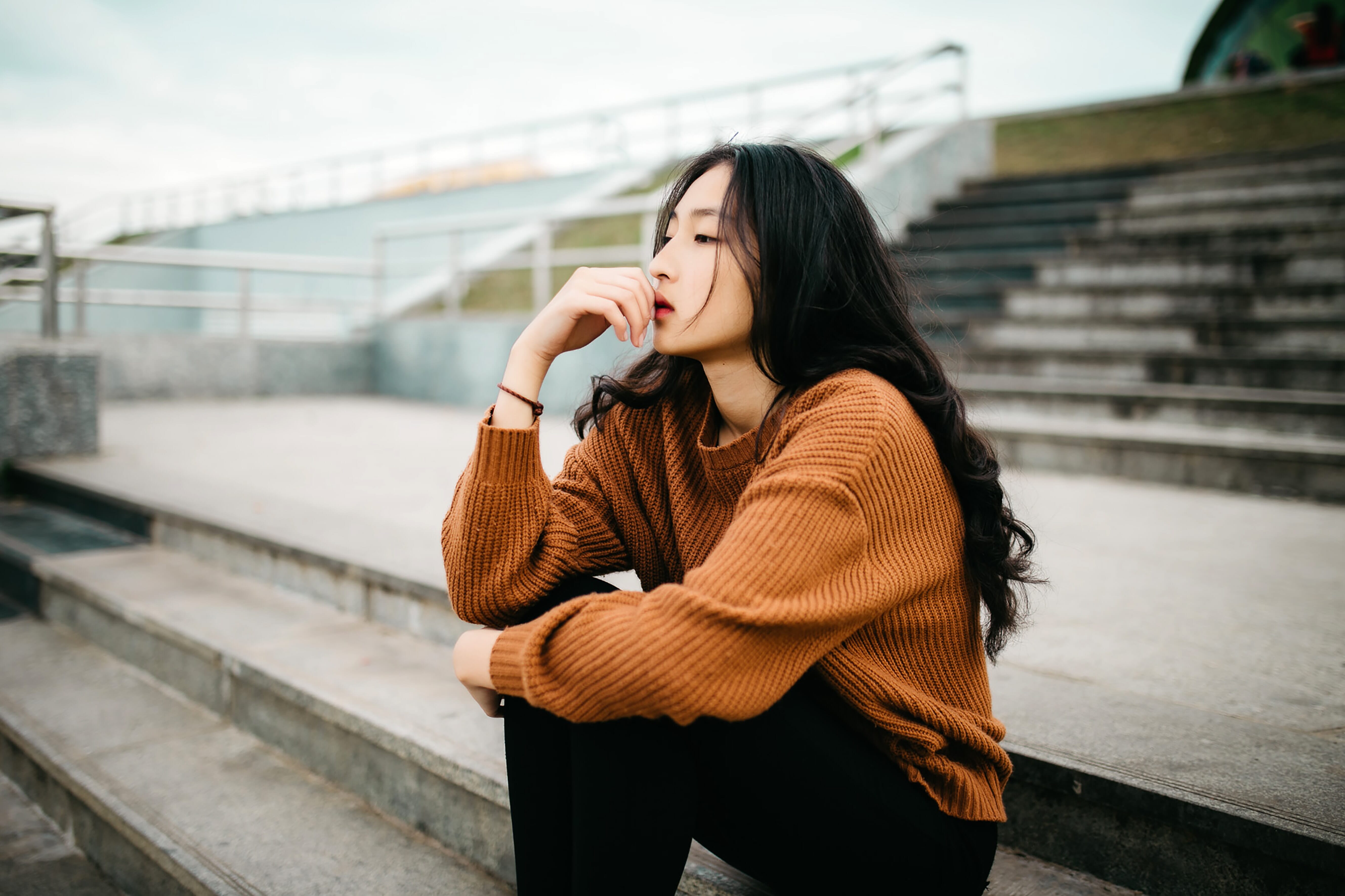 contemplative woman sitting on stadium steps