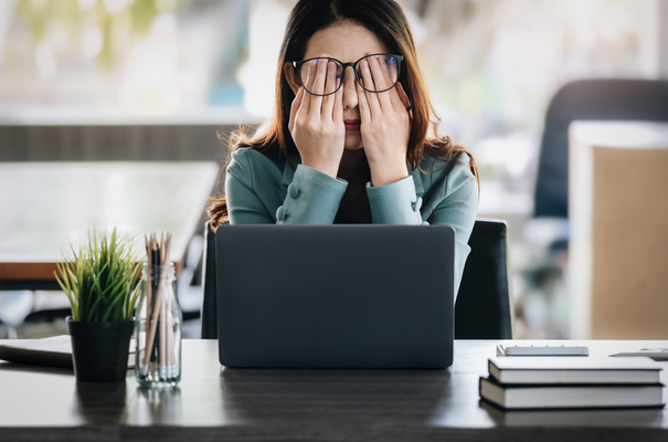 woman in pain sitting at her computer