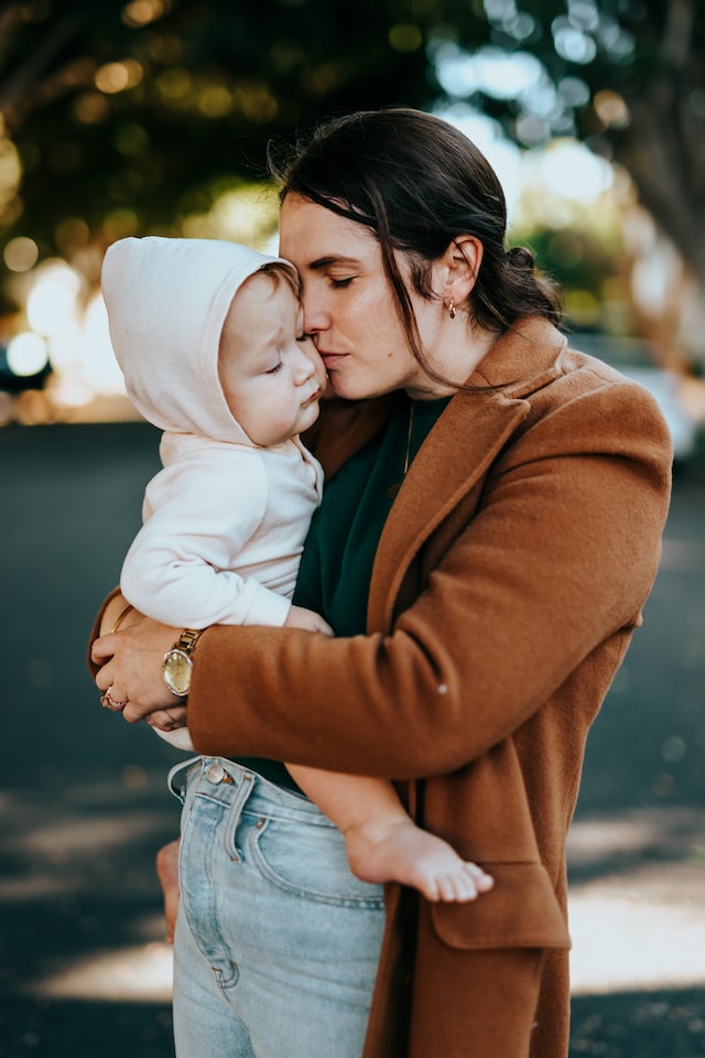 woman kissing her baby