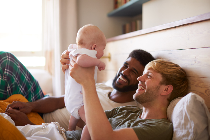 gay couple holding their new baby