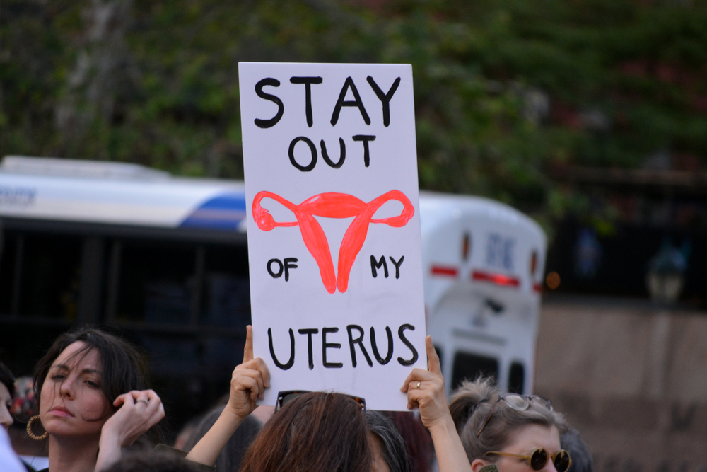 pro-choice protestors holding sign that reads "stay out of my uterus"